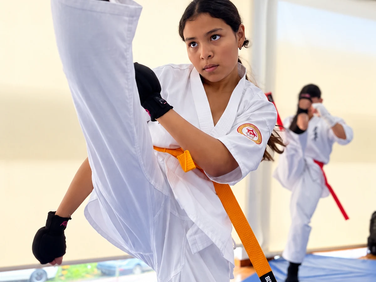 Adolescente practicando una patada de karate en Okami Dojo